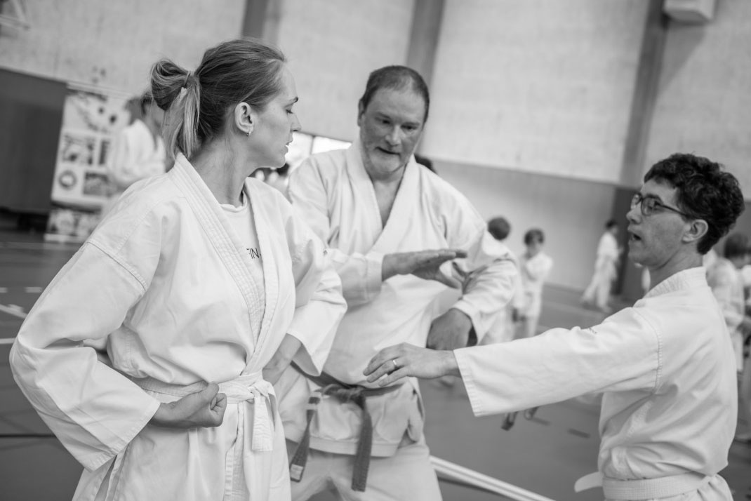 Kris, legt een basis afweer uit aan 2 karateka's tijdens een training
